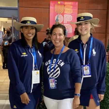 Three people at US Open event smiling.